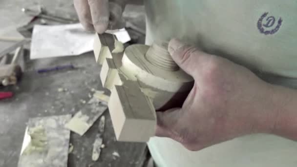 Unrecognizable carpenter applies glue to wooden parts. Handwork concept, woodworking workshop. Focus on hands.
