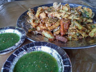 Hindistan 'da yol kenarındaki bir tezgahta çay ve pakodas resmi. En ünlüleri Hindistan 'da yemek yiyor..