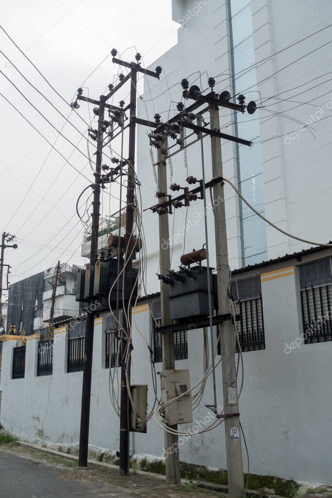 Electricity poles with overhead transformers in India.