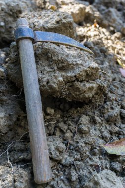 Özellikle bahçelerde küçük yumuşak yüzey kazmak için kullanılan küçük, tek taraflı bir kazma..