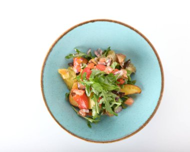 Domatesli sebze salatası ve beyaz tabakta otlar. 