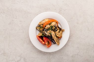 Gri arka planda tavuklu kızarmış sebze.