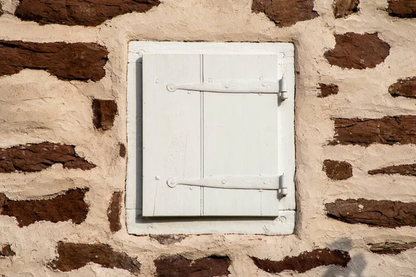 Taş duvarda kepenk olan koloni pencere çerçevesi — Stok fotoğraf