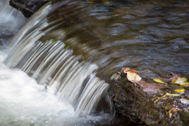 Kayaların üzerine dökülen bir derenin soyut maruziyeti.