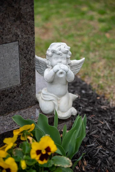 Cemitério querubim anjo toca a trombeta em uma pedra de sepultura — Fotografia de Stock