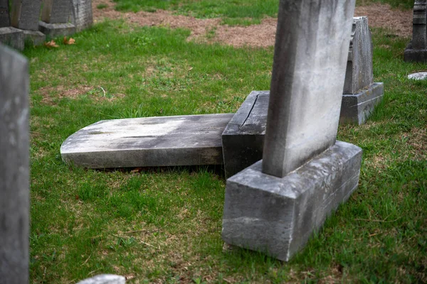 Toppled old grave stone tombstone gr4een grass cemetery — Stock Photo, Image