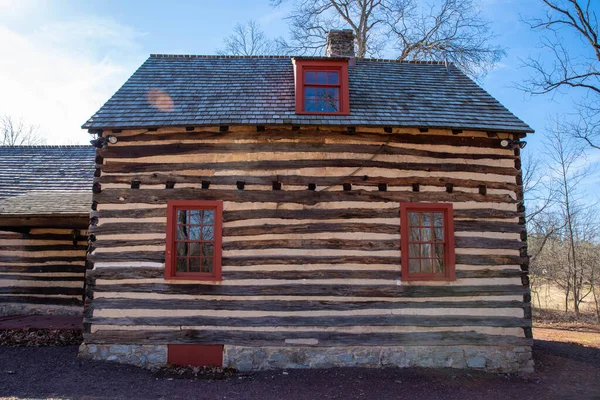 Grandes ventanas rojas en la cabaña de troncos históricos que reflejan árboles. —  Fotos de Stock