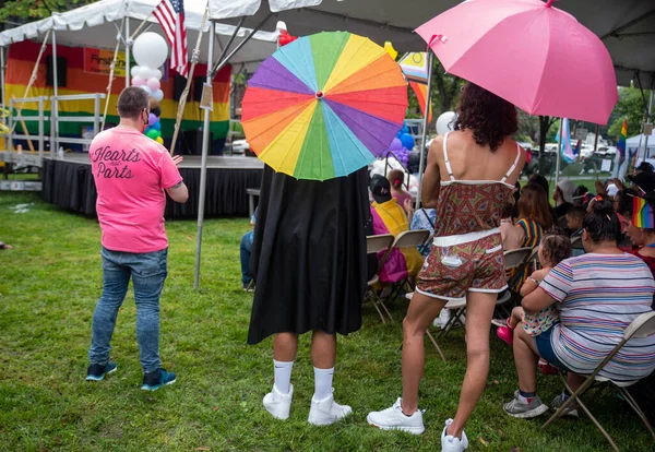 Espectadores con paraguas de arco iris ven un espectáculo en un Festival del Orgullo. — Foto de Stock