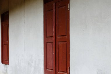 Kırsal dokuyu ve basit mimariyi gösteren yıpranmış ahşap pencerenin yan görüntüsü