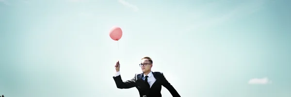 Empresário com balão ao ar livre — Fotografia de Stock