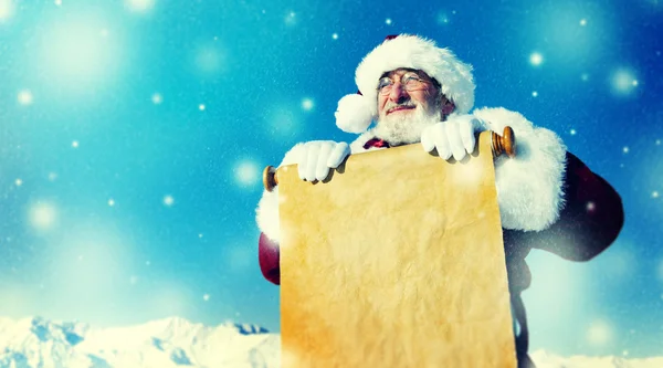 Weihnachtsmann mit Papierrolle — Stockfoto