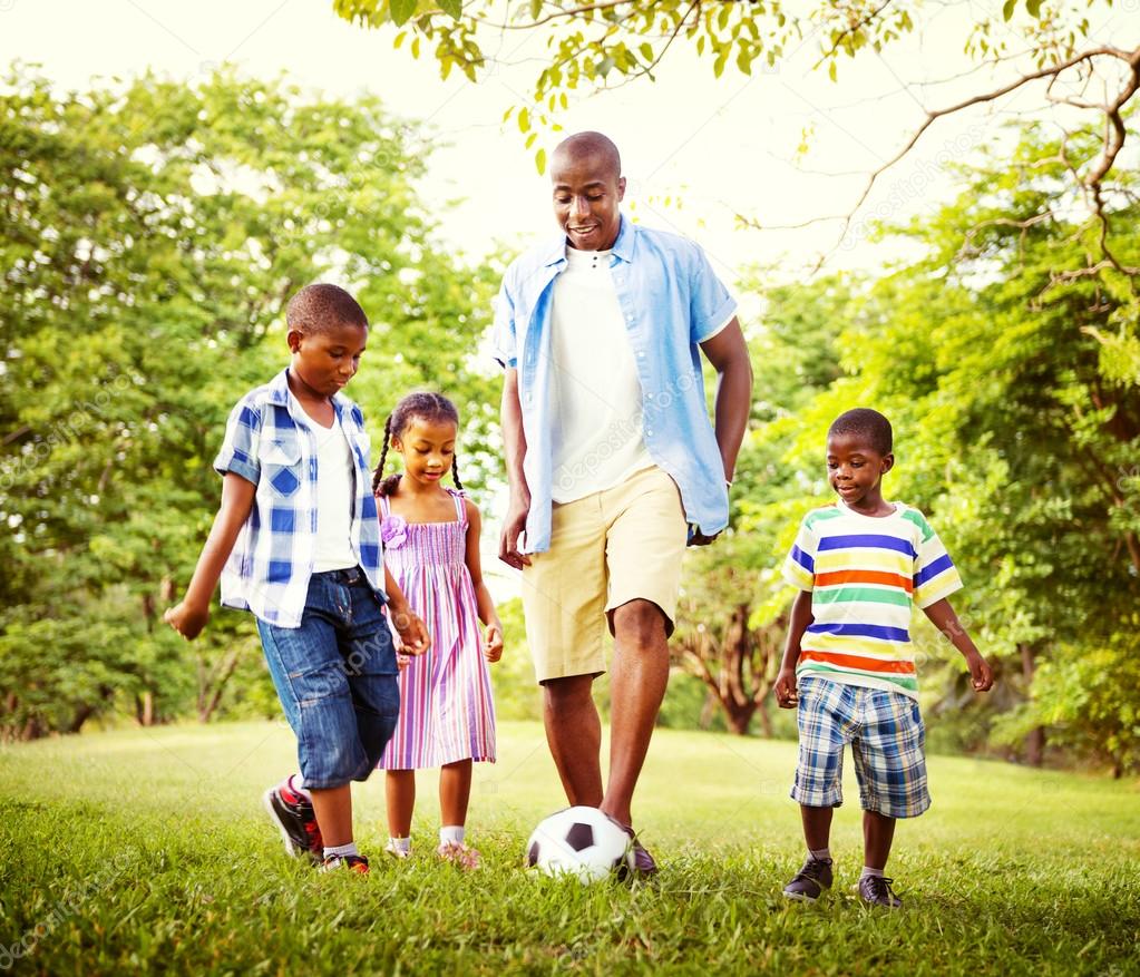 Father playing football with children Stock