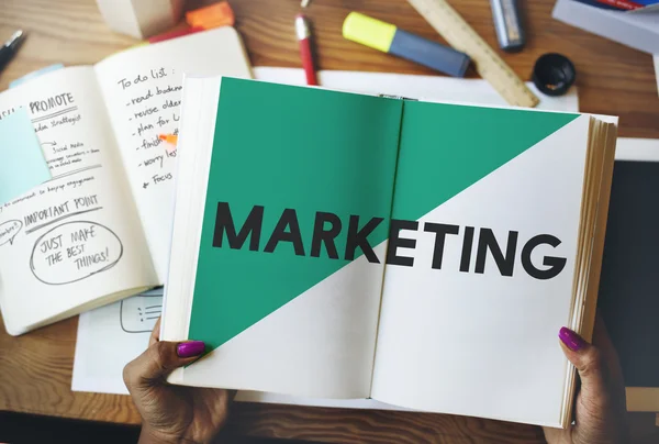 Woman holding book with marketing — Stock Photo, Image