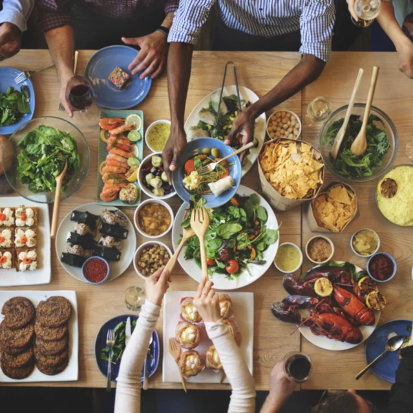 Друзья едят за большим столом — стоковое фото