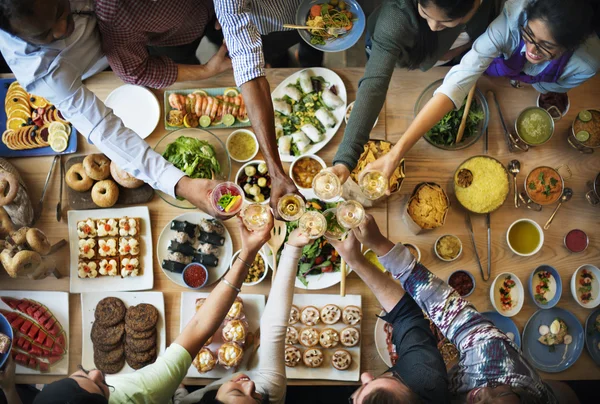 Amigos comiendo para la mesa grande —  Fotos de Stock