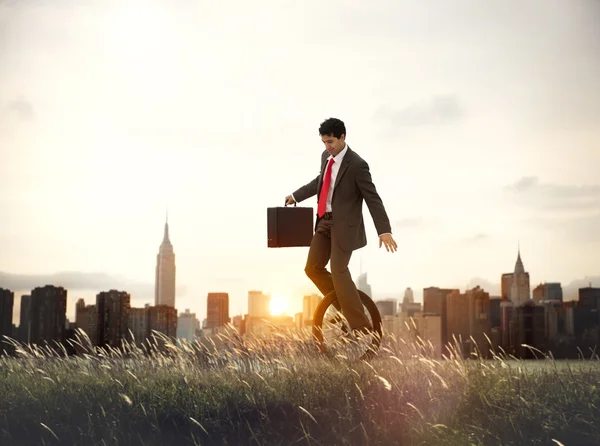 Businessman riding one wheel bicycle — Stock Photo, Image