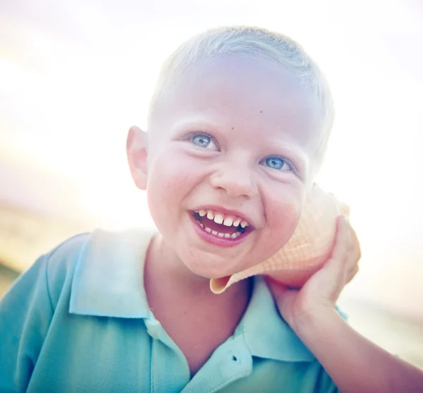 Malý kluk s úsměvem na pláži — Stock fotografie