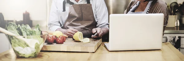 Couple Cooking at Kitchen with laptop — Stock Photo, Image