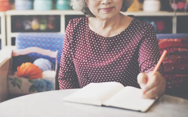 Starsza kobieta pisania na notebooka — Zdjęcie stockowe