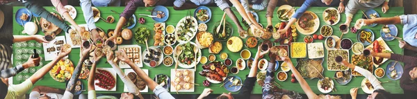 Amigos comiendo para la mesa grande —  Fotos de Stock