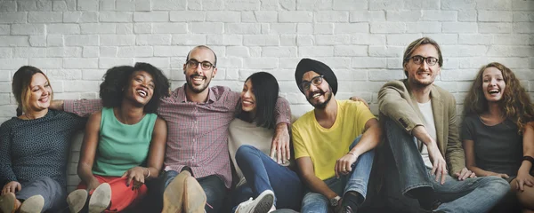 Diversidade amigos perto da parede de tijolo — Fotografia de Stock