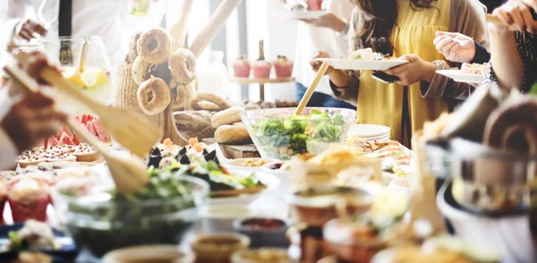 Amigos com diferentes alimentos e bebidas — Fotografia de Stock