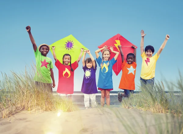 Barn som leker på stranden med kite — Stockfoto