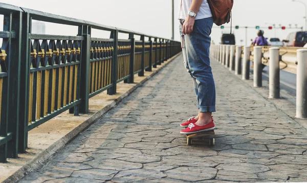 Ragazza su Skateboard su pavimentazione in cemento — Foto Stock