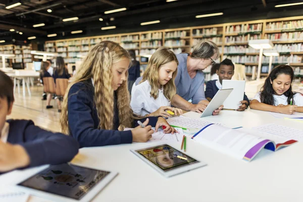 Crianças estudando na biblioteca — Fotografia de Stock