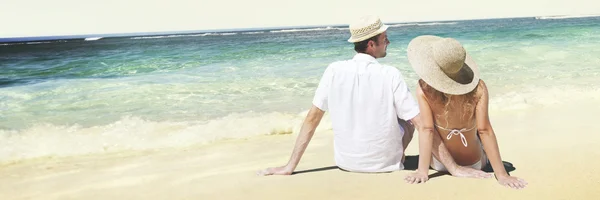 Пара сидить на пляжі — стокове фото