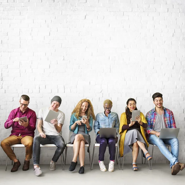 Diversidad de personas sentadas con dispositivos digitales —  Fotos de Stock