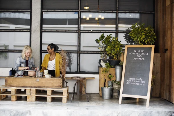 Vrouwen zitten in de buurt van café — Stockfoto