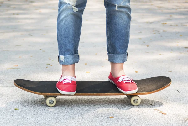 Ragazza su Skateboard su pavimentazione in cemento — Foto Stock