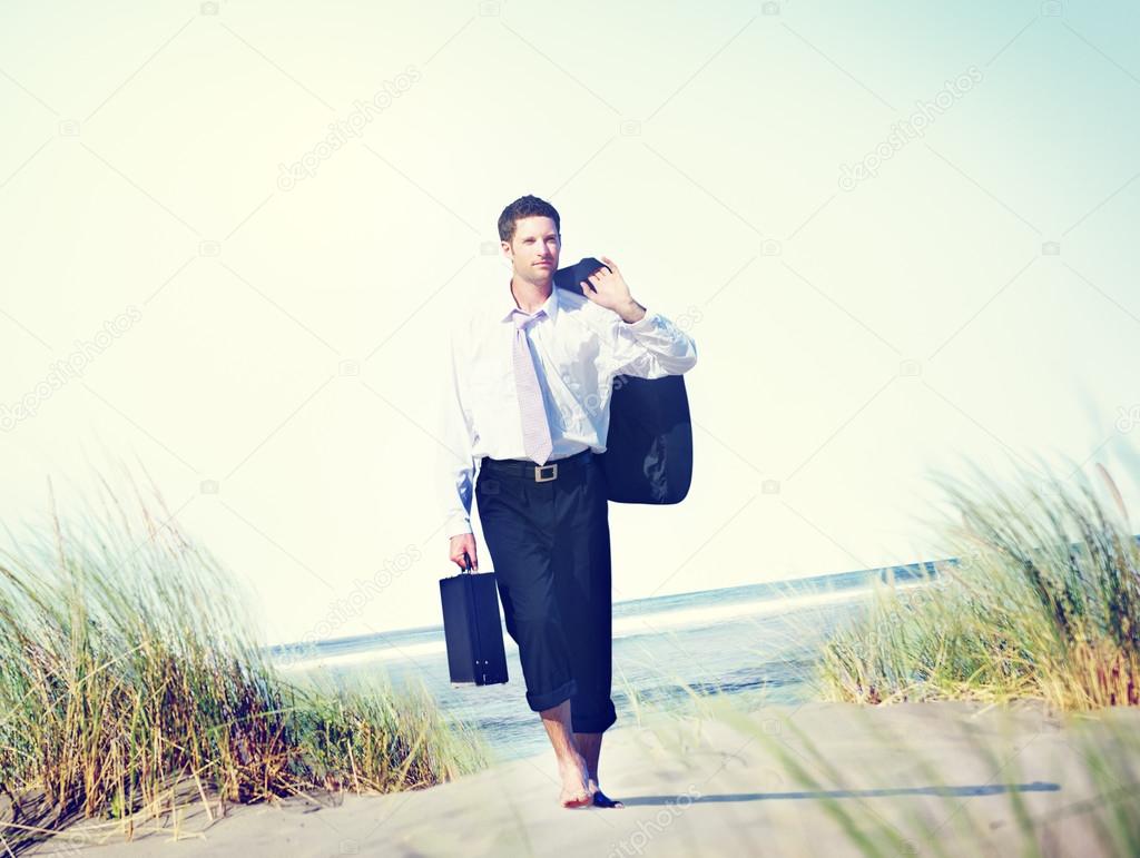 Businessman walking on beach