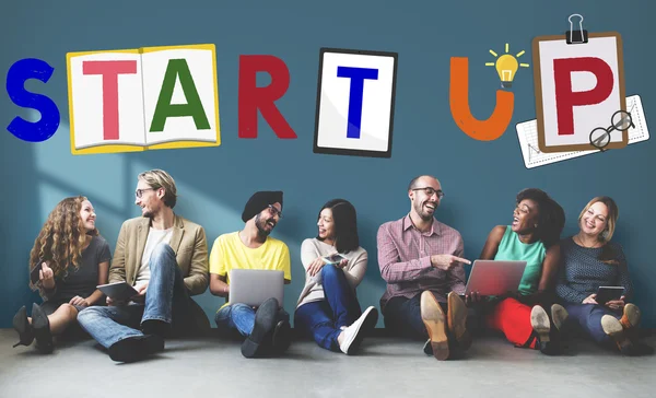 Diversity friends near wall with startup — Stock Photo, Image