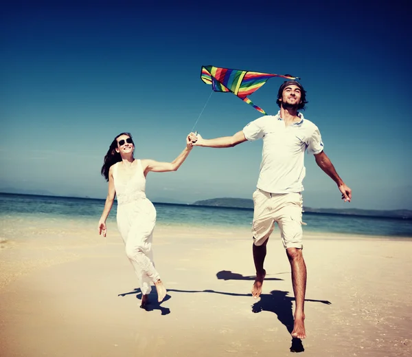 Casal jogando pipa na praia — Fotografia de Stock