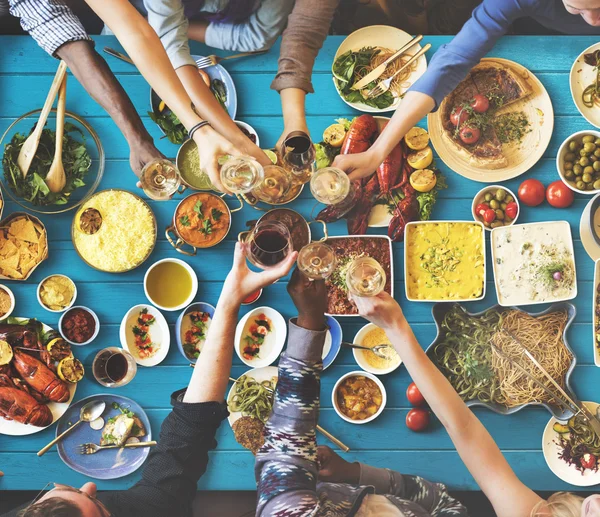 Друзья едят за большим столом — стоковое фото