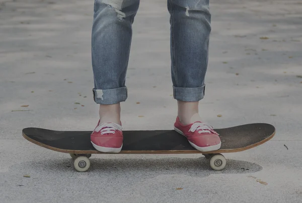 Ragazza su Skateboard su pavimentazione in cemento — Foto Stock