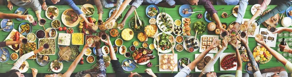 Друзі їдять за великий стіл — стокове фото