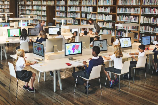 Crianças estudando na biblioteca — Fotografia de Stock