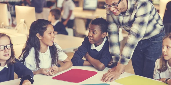 Camarades de classe ayant des leçons avec l'enseignant — Photo