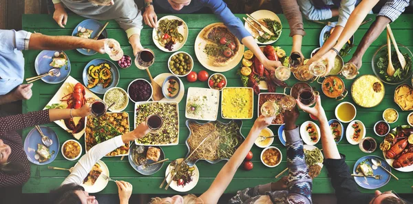 Amigos comiendo para la mesa grande — Foto de Stock