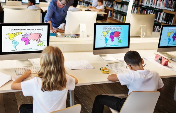 Crianças estudando na biblioteca — Fotografia de Stock