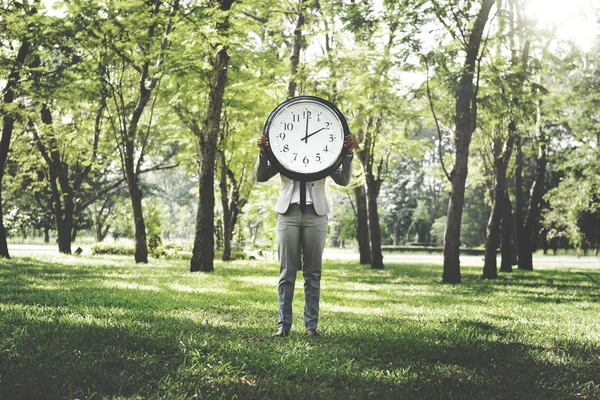 Бізнес-леді на відкритому повітрі тримає годинник — стокове фото