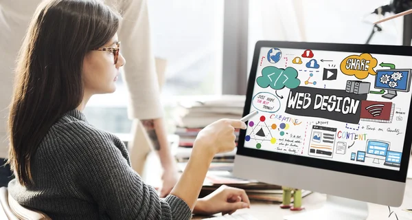 Kvinnan visar på monitor med webbdesign — Stockfoto