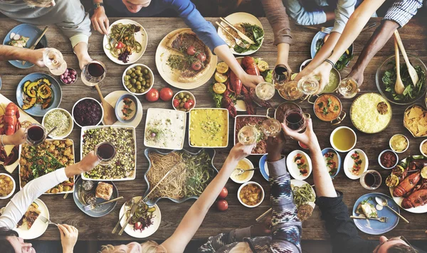 Amigos comendo para grande mesa — Fotografia de Stock