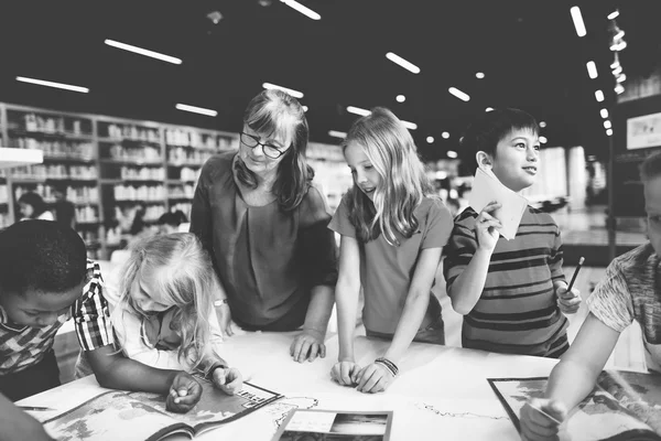 Kinderen die studeren in de bibliotheek — Stockfoto