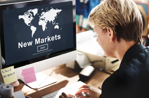 Zakenvrouw met nieuwe markten op monitor — Stockfoto