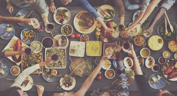 Amigos comendo para grande mesa — Fotografia de Stock