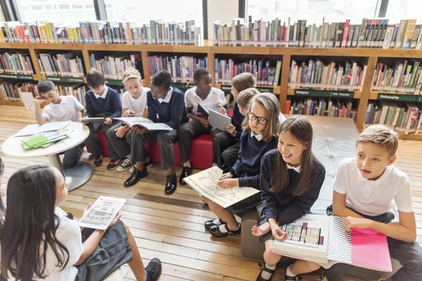 Klasgenoten lezen van boeken in bibliotheek — Stockfoto